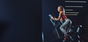 woman exercising on stationary bike wondering if Ciclozone, indoor cycling app, is for her